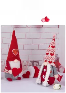 Close-up of Valentine's Day gnomes with heart sequins and knit textures on a white brick background