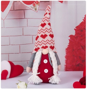 Close-up of Valentine gnome with knitted heart hat and white braids for home decor
