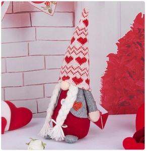 Detail of a plush Valentine's gnome with red heart patches and long white braids