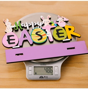Detailed view of wooden Happy Easter bunny ornament on scale weighing 48.6g