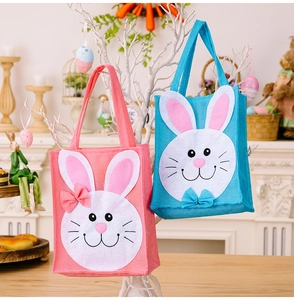 Detailed view of pink and blue Easter bunny gift bags hanging on white branches
