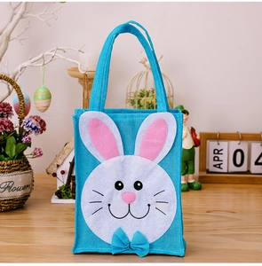 Blue linen Easter bunny gift bag with white applique and pink ears on wooden table