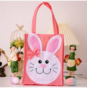 Pink burlap Easter tote bag with white bunny applique and bow in a festive setting