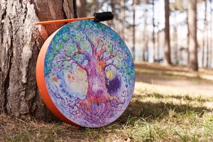 Detail of colorful Tree of Life shaman drum against a natural forest background