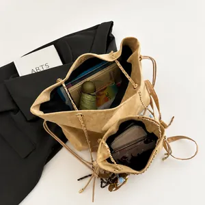 Interior view of khaki suede tote bag with drawstring closure and metal chain strap