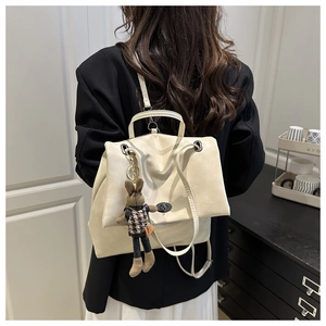 Detail of cream leather backpack with metal twist lock and cute bunny doll accessory