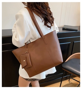 Détail d'un grand sac cabas en similicuir marron foncé avec une pochette amovible
