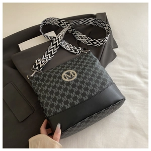 Detail of crossbody bag featuring monogram texture and wide geometric shoulder strap