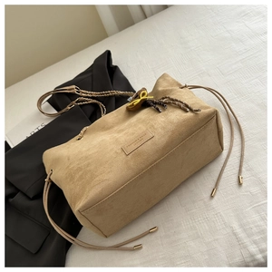 Dettaglio della borsa tote in pelle scamosciata kaki con chiusura a coulisse e ciondolo