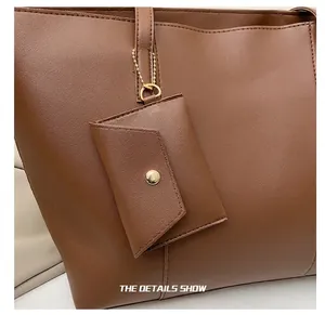 Détail du cabas en cuir marron avec mini pochette enveloppe assortie et chaîne dorée