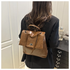 Retro brown leather backpack with metal turn-lock and adjustable straps shown on model