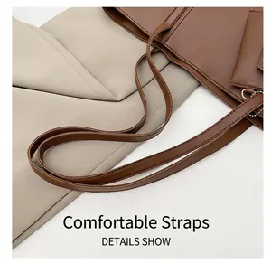 Détail montrant les bretelles confortables et le porte-monnaie assorti sur le grand sac brun