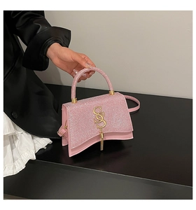 Detail of pink sequin handbag featuring a gold SS logo and metallic fringe pendant