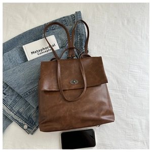 Flat lay detail of dark brown vintage faux leather backpack with metal turn-lock