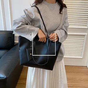 Détail du sac cabas noir avec mini pochette montrant la texture du cuir synthétique
