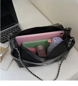 Interior view showing the large capacity of the black tote bag with laptop and tablet