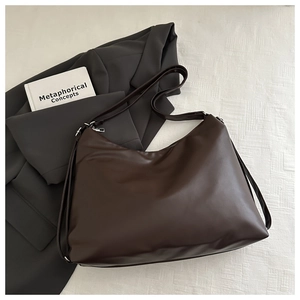 Macro shot of dark brown matte PU leather shoulder bag with silver hardware details