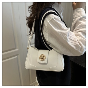 Close-up of white minimalist shoulder bag featuring an embossed golden vintage lock