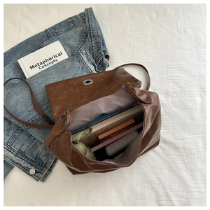 Top view of brown PU leather backpack interior showing storage of book and umbrella