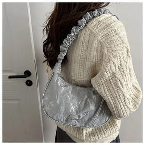 Dettaglio della borsa hobo argento metallizzato con tracolla scrunchie e pieghe lucide