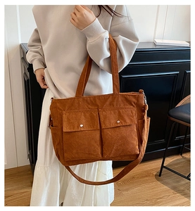 Detailaufnahme der braunen Cord-Tragetasche mit doppelten Fronttaschen und Schnallen