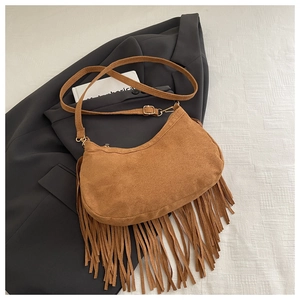 Dettaglio della borsa in pelle scamosciata marrone con lunghe nappe su un blazer