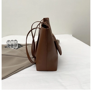 Vue latérale détaillée d'un cabas en cuir marron montrant la texture et la bandoulière