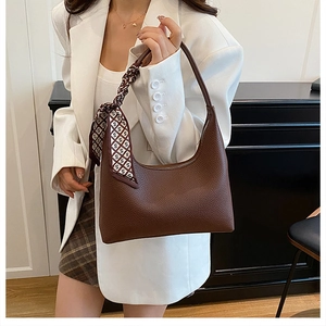 Détail du sac hobo marron grainé avec foulard en soie et fermeture éclair en métal