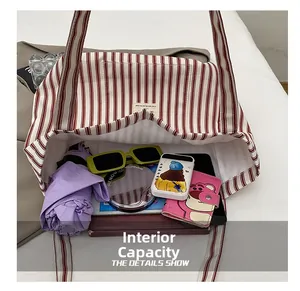 Detailed view of striped canvas tote interior with large capacity and inner pocket