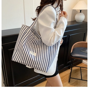 Detailed shot of large capacity blue striped canvas tote bag showing the side profile view