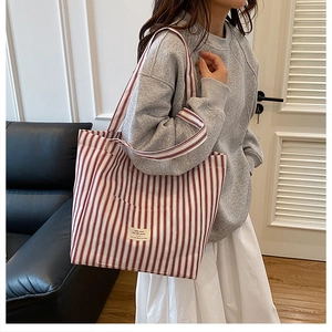 Close-up of red and white striped canvas tote bag with a minimalist woven brand label