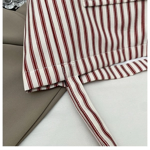 Macro detail of red and white striped canvas tote bag with reinforced stitching
