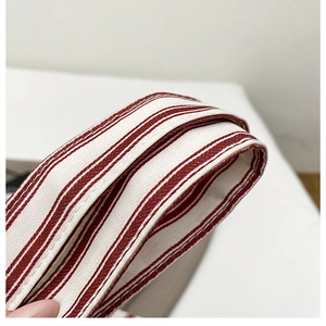 Close-up of red and white striped canvas tote handle showing durable woven texture