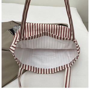 Internal view of striped canvas tote bag showing white lining and spacious inner pocket