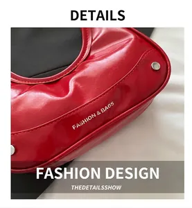 Detail of red patent leather shoulder bag featuring silver rivets and fashion text print