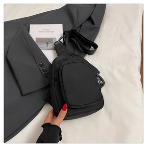 Détail du sac de poitrine minimaliste en nylon noir avec sangle réglable et poche