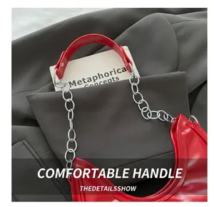 Detail of red glossy patent leather handbag with thick silver chain and sturdy handle