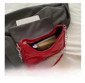 Interior view of red glossy patent leather shoulder bag showing spacious storage capacity