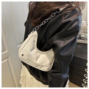 Close-up of a white crescent shoulder bag with silver chain strap and metal rivet details