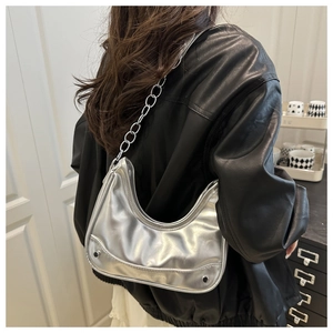 Close-up of silver metallic hobo bag featuring chain strap and fashion embossed text