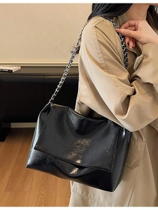 Chic black crinkle texture chain shoulder bag for women shown with a stylish trench coat