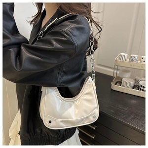 Detail view of white crescent bag featuring silver chunky chain and stud accents