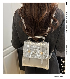 Detail of silver woven leather mini backpack showing metallic texture and gold ring buckle