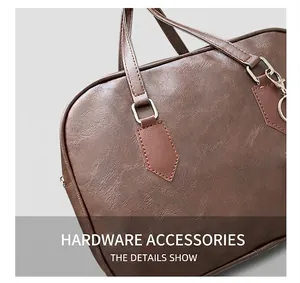 Detail of silver metal D-ring hardware and brown lychee grain leather on bowling bag
