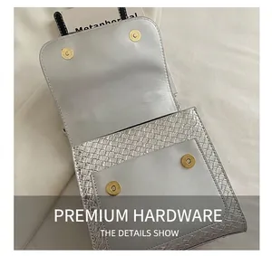 Detail of silver woven texture bag with magnetic gold buckle on denim fabric