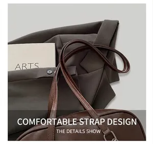 Detail of vintage brown textured leather handbag with slender shoulder strap and metal hardware
