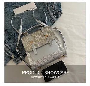 Silver-gray crossbody bag size comparison with a smartphone and woven texture detail