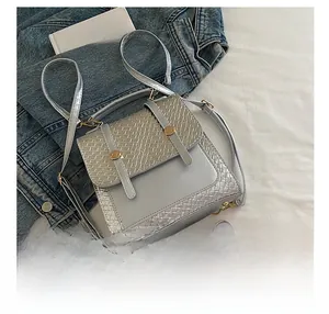 Silver-gray crossbody bag size comparison with a smartphone and woven texture detail