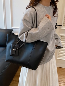 Sac cabas minimaliste en similicuir noir avec petite pochette dans une scène de vie