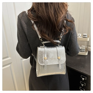 Détail d'un sac à dos en cuir PU tressé argenté avec ferrures dorées et rabat de fermeture